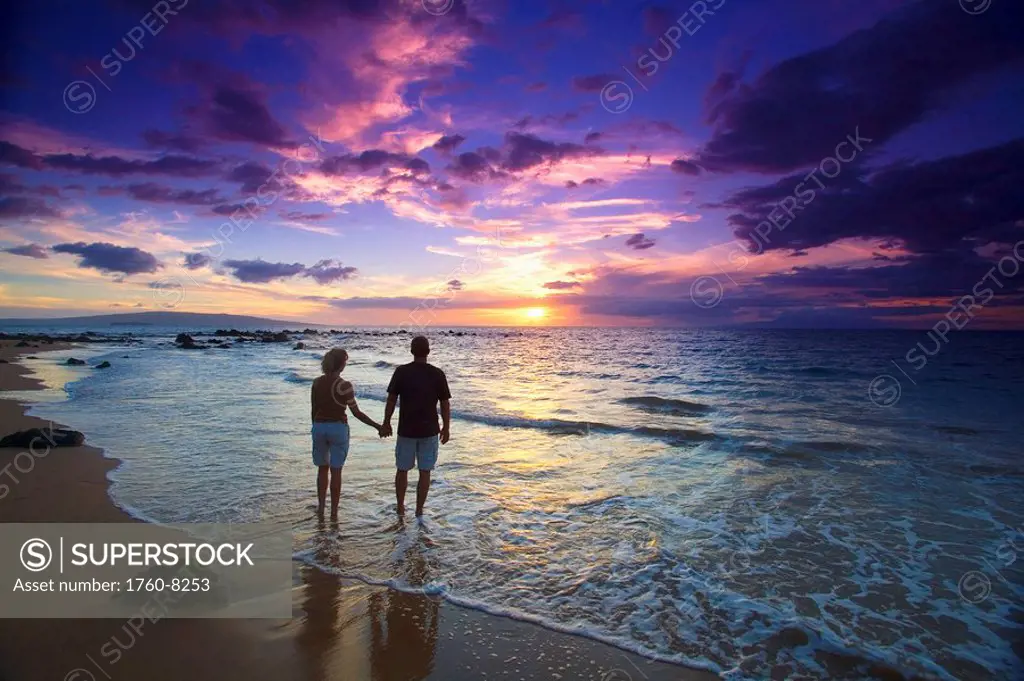 Hawaii, Maui, Wailea, Mokapu Beach, Silhouetted couple watching sunset.