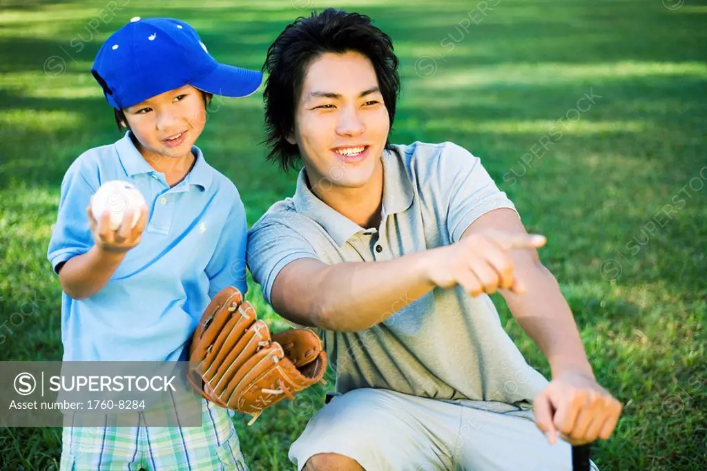 Young Japanese father and child playing baseball.