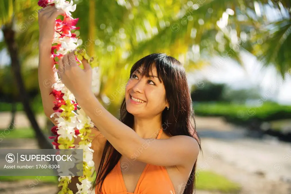 Young Japanese girl holding lei.