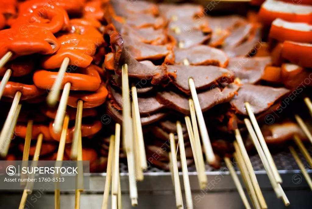 Hong Kong, Causeway Bay, Barbecued pork and chicken being grill at a street food vendor´s stall.