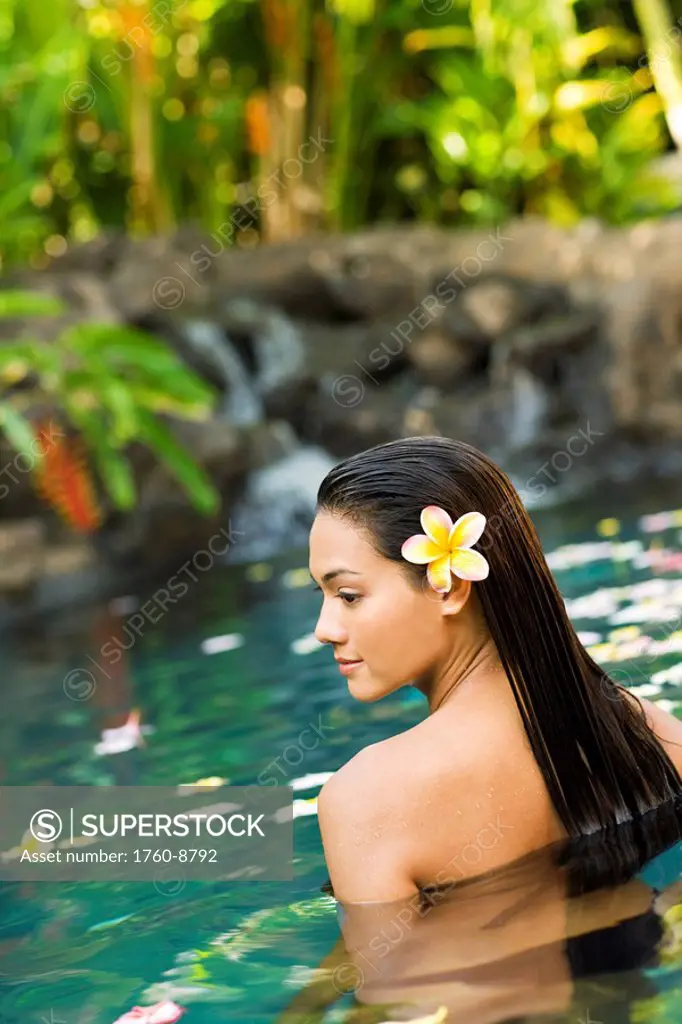 Hawaii, Oahu, Young woman relaxing in tropical pool.