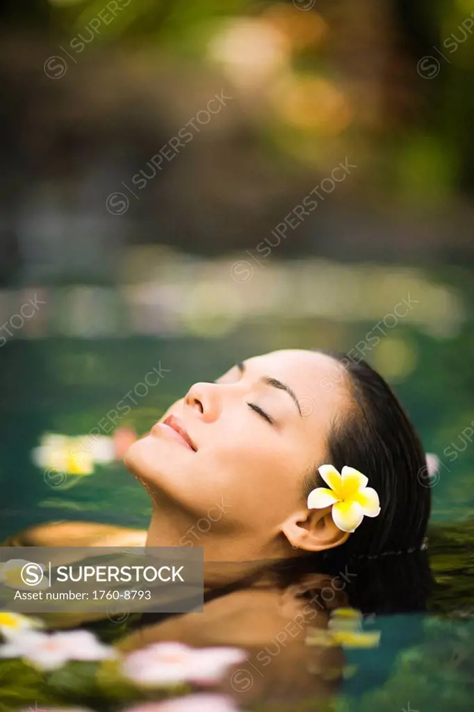 Hawaii, Oahu, Closeup of young woman´s face relaxing in tropical pool.