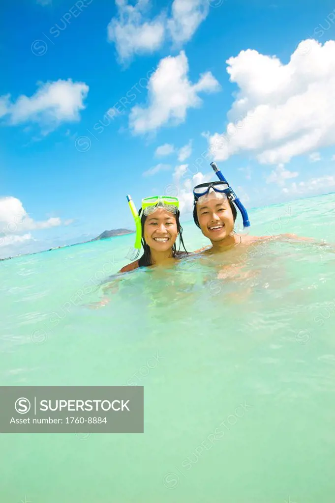 Hawaii, Oahu, Lanikai, Japanese couple in the ocean with snorkel gear.