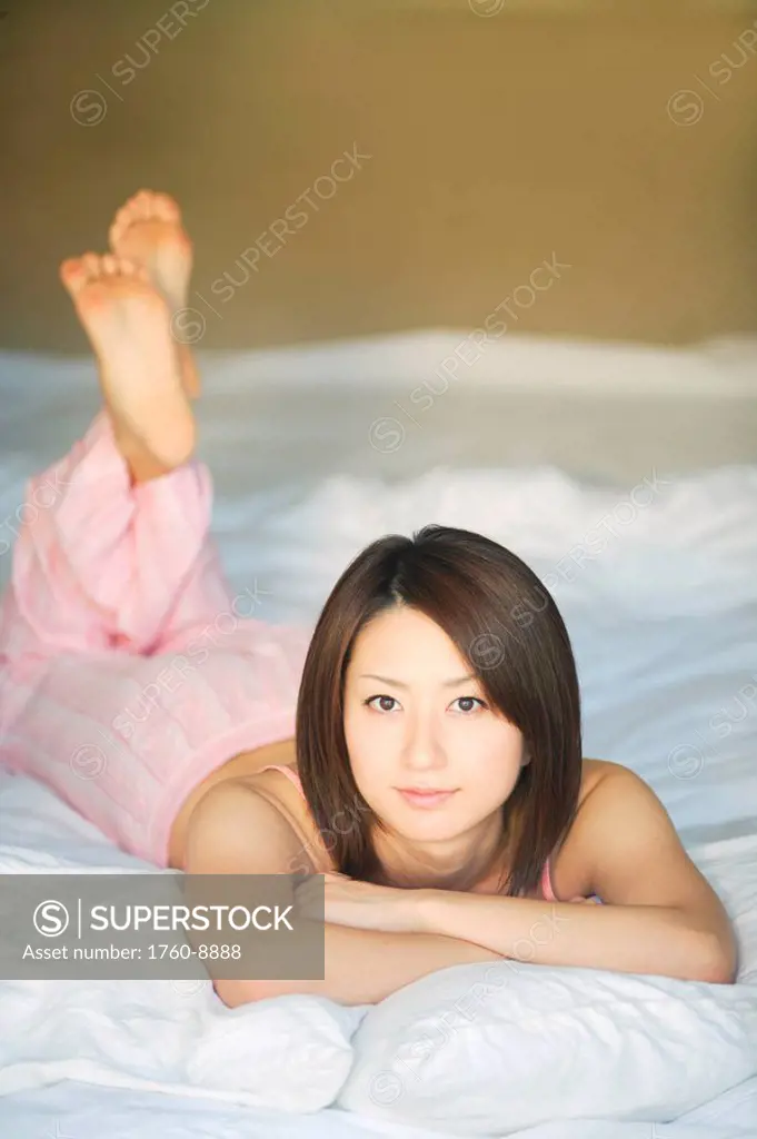 Young Japanese woman resting in her bedroom.