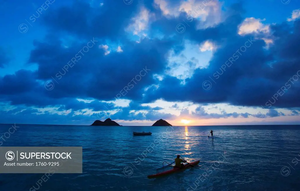 Hawaii, Oahu, Lanikai, Canoe paddler and Stand up paddler early morning sunrise on the beach.
