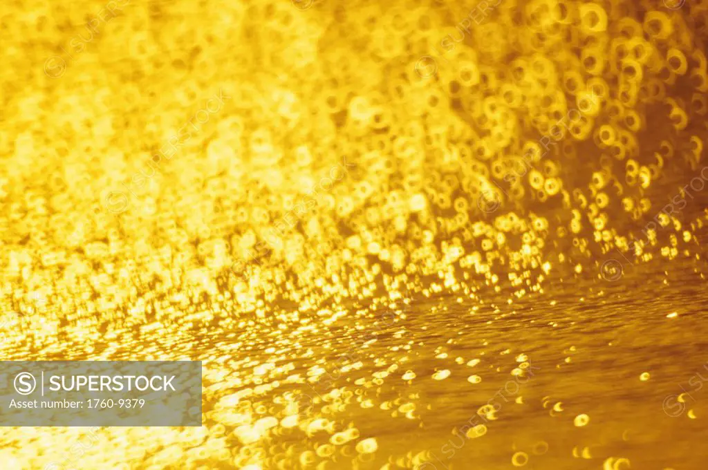 Closeup of golden shimmering reflections off water.