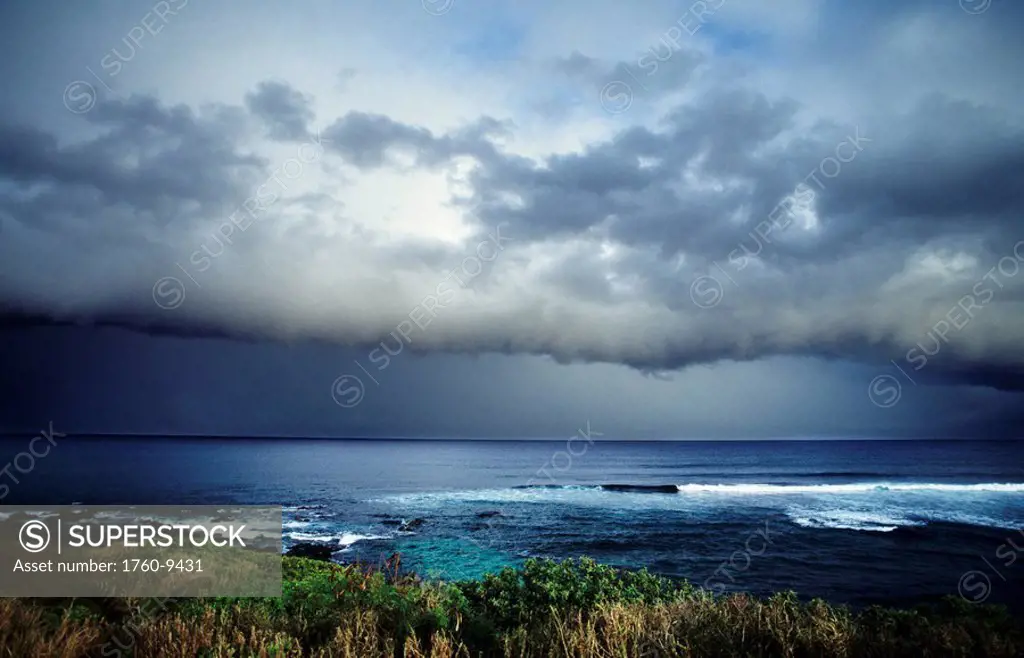 Hawaii, Maui, North Shore, Storm front clouds overlooking ocean from hillside.