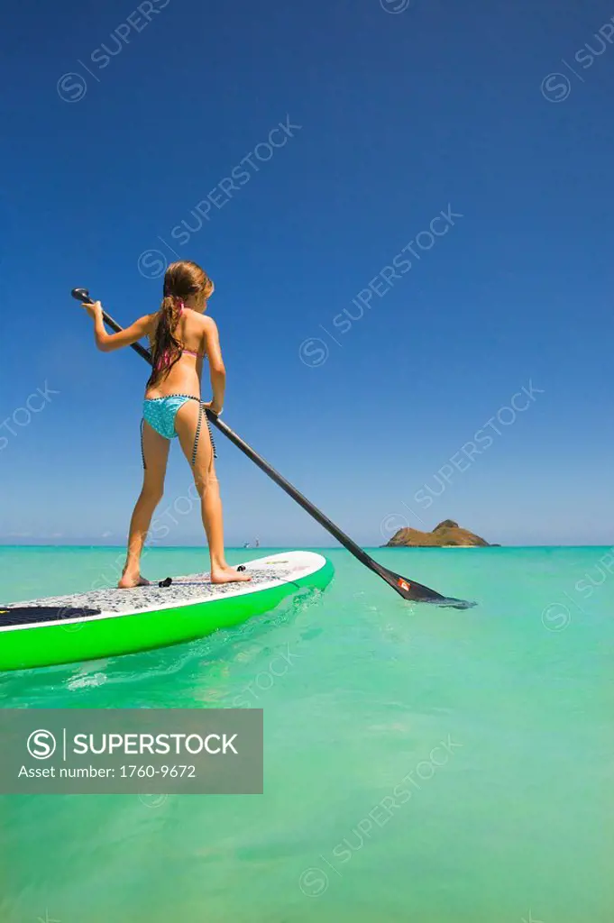 Hawaii, Oahu, Lanikai, Young girl stand up paddling.