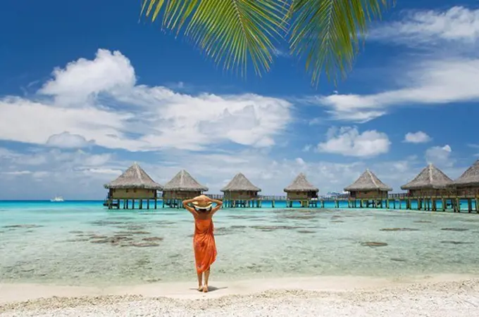 French Polynesia, Tuamotu Islands, Rangiroa Atoll, Woman on beach near luxury resort.
