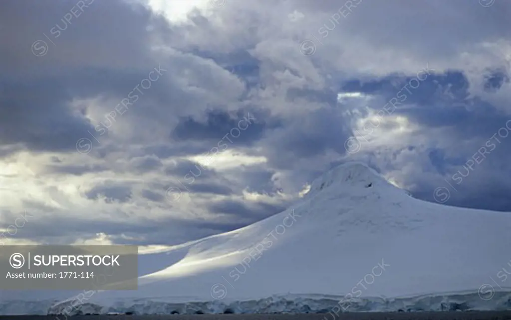 Clouds over a snow covered mountain, Paradise Bay, Antarctic Peninsula, Antarctica