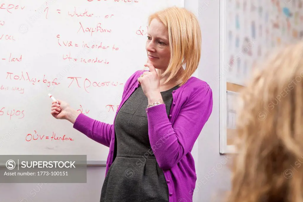 Teacher standing at whiteboard in class