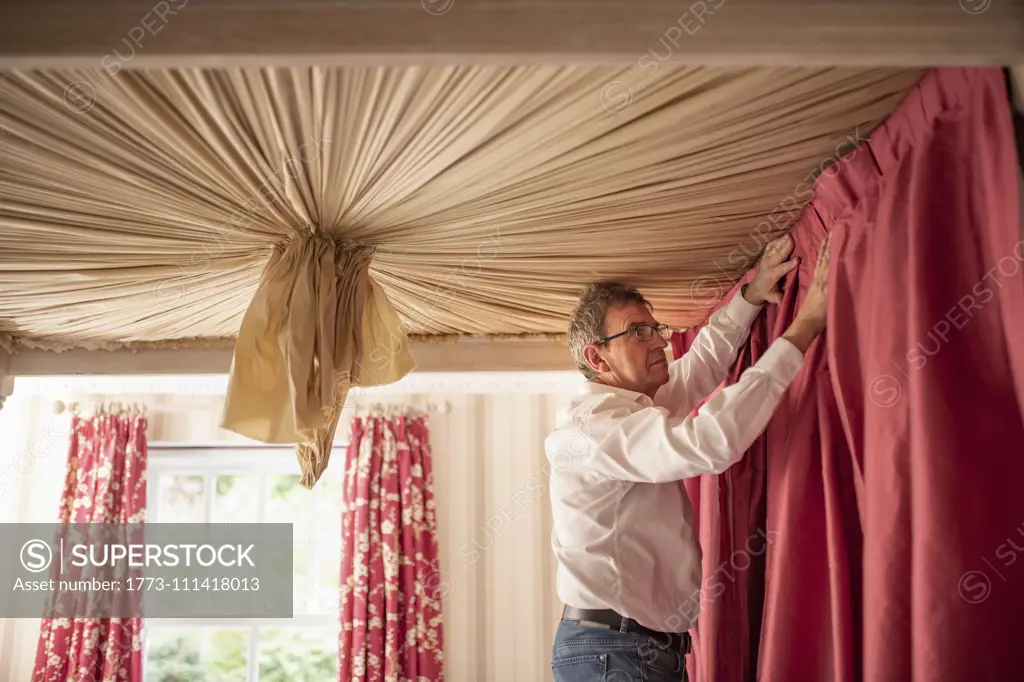 Curtain fitter fitting drapes to four poster bed