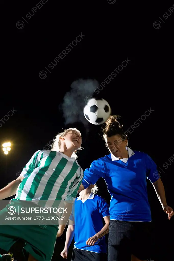 Female soccer players hitting ball with head