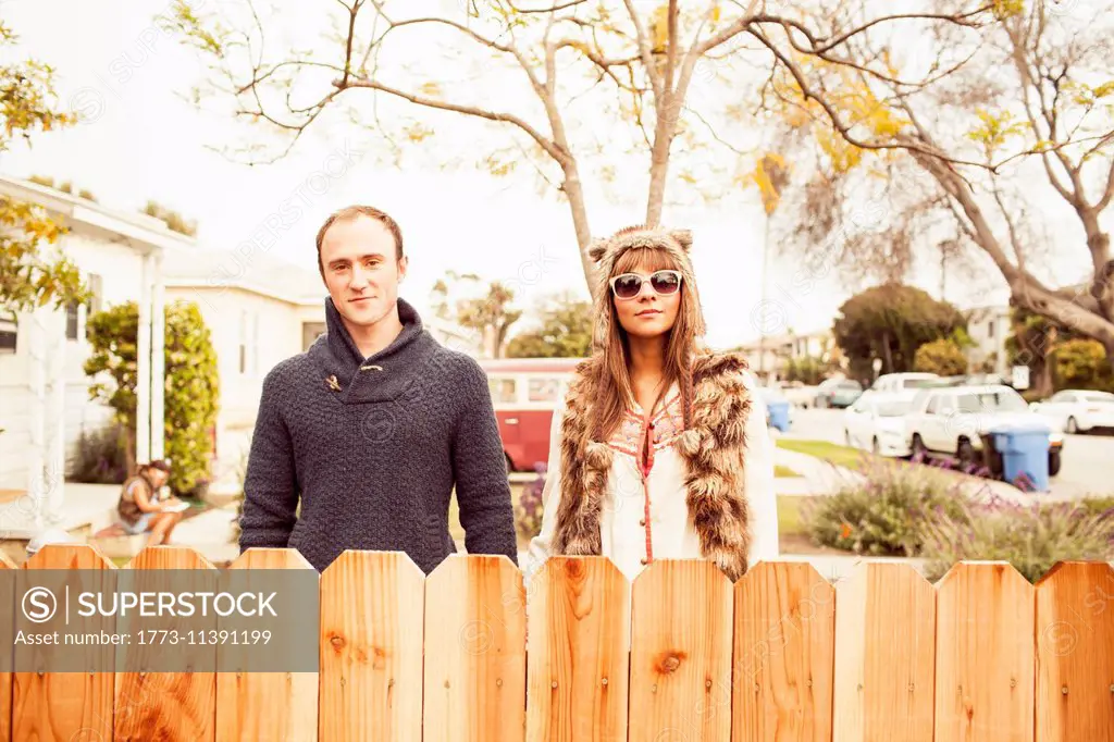 Couple behind wooden fence