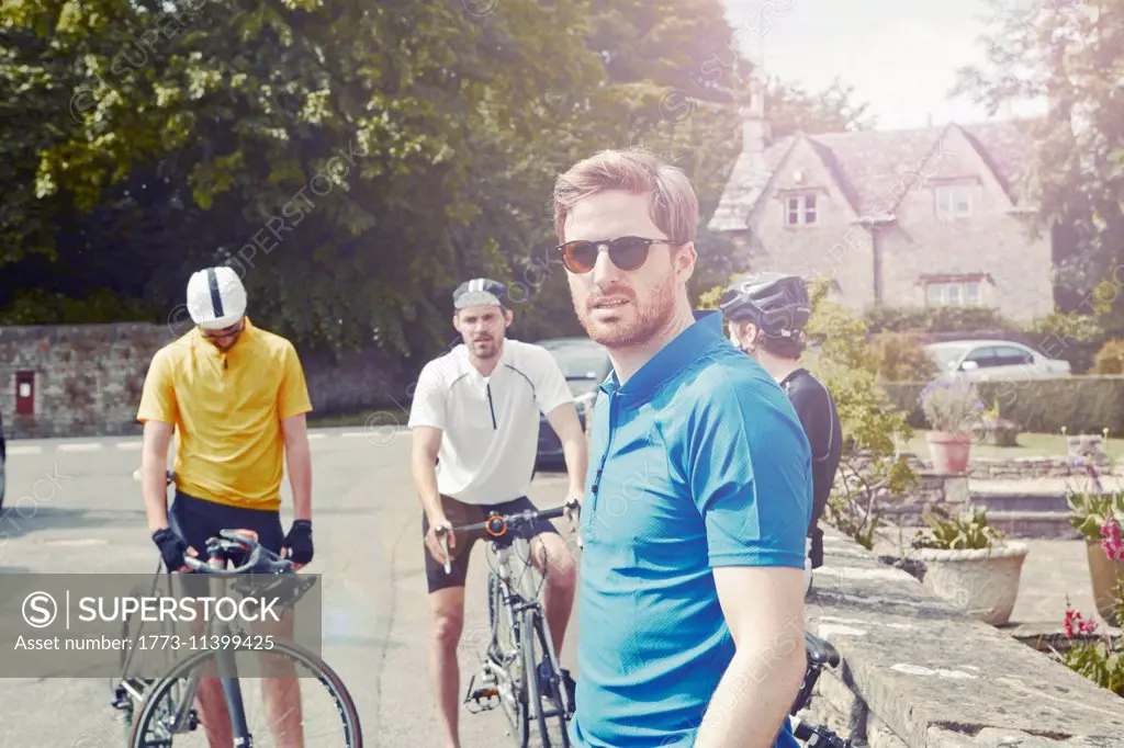 Cyclists stopping by stone wall, Cotswolds, UK