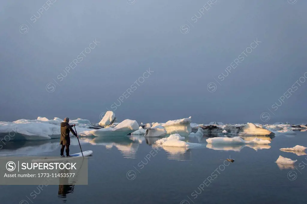 Man on paddleboard, Jokulsarlon Glacier Lagoon, Skaftafell National Park, Iceland