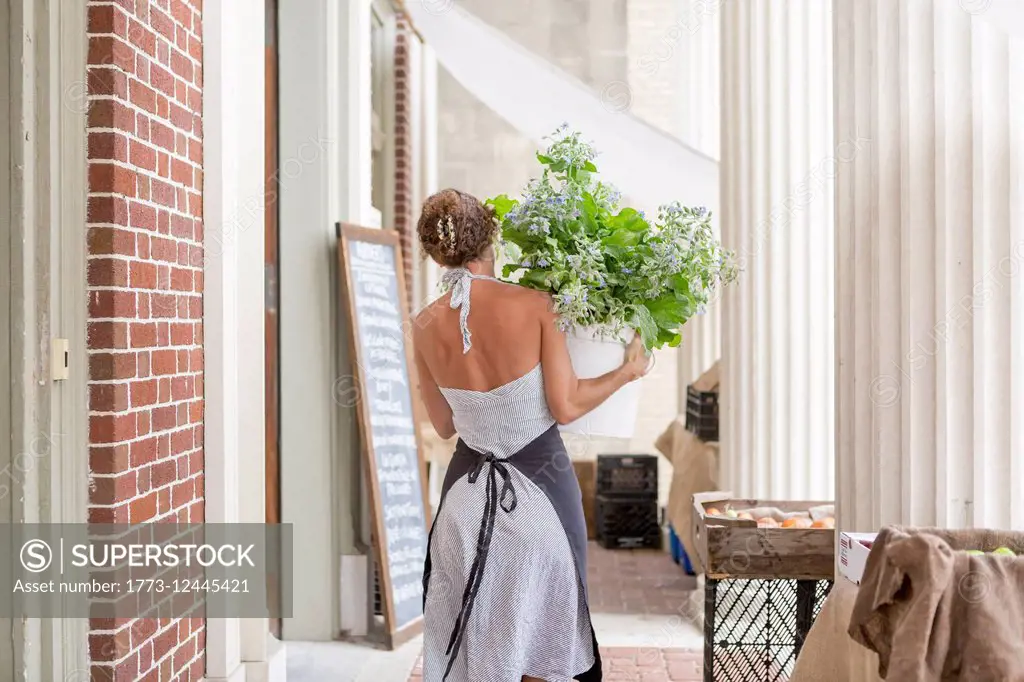 A woman unloads organic goods outside a grocery store