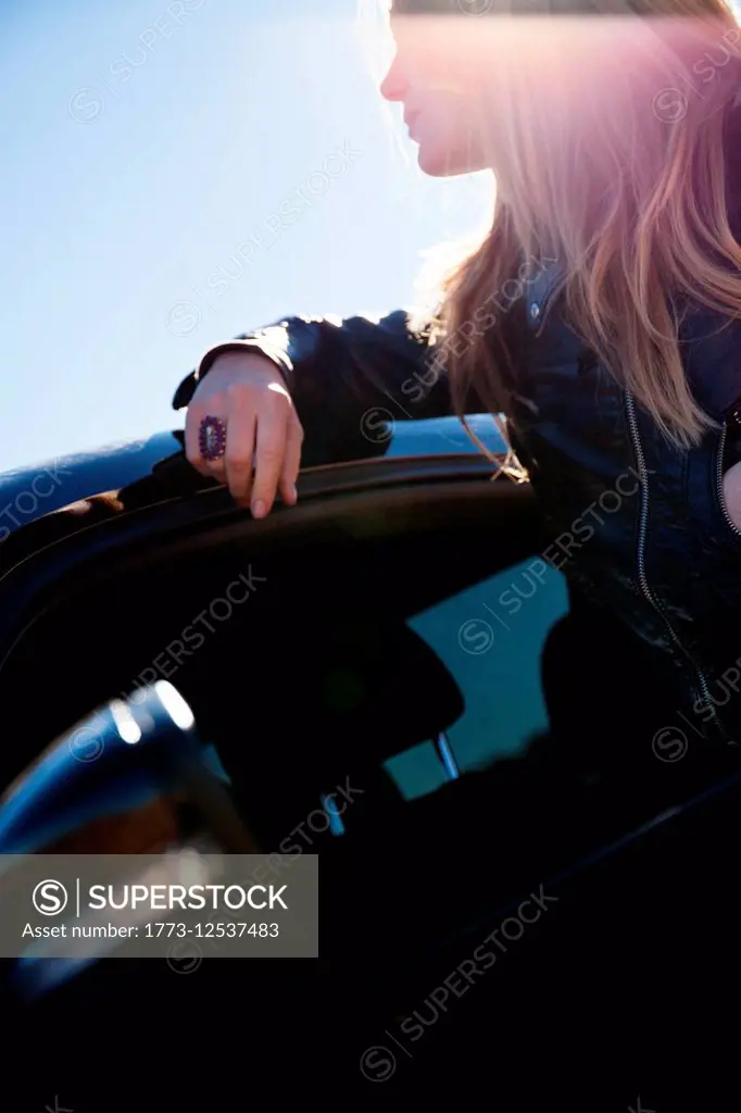 Woman leaning on car