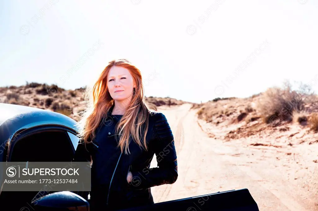 Woman standing beside car, Kayenta, Arizona, USA