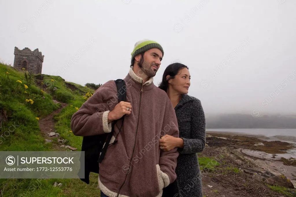 Mid adult couple strolling on misty coast, Dingle Peninsula, Ireland