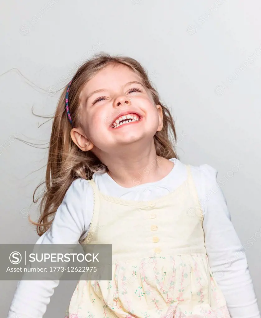 Studio portrait of cute girl laughing