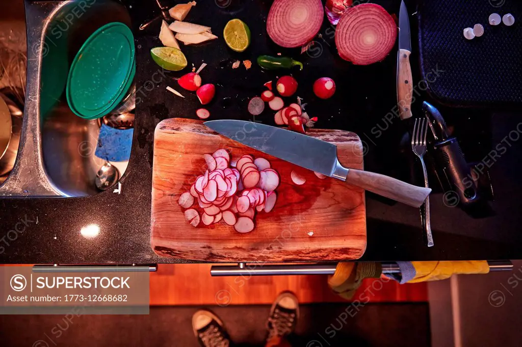 Sliced radish, onion and lime halves, chopping board and knife