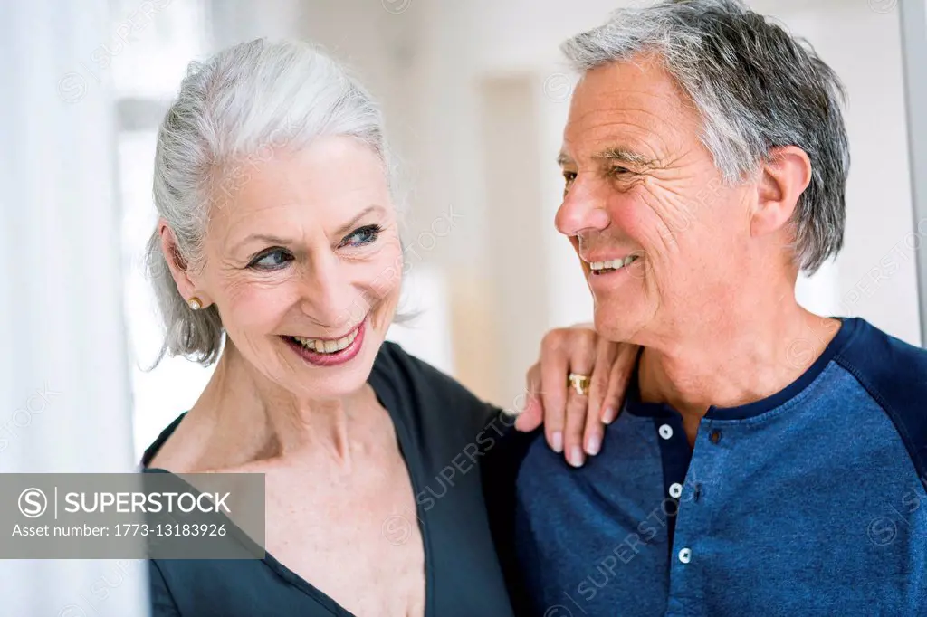 Senior woman with hand on senior mans shoulder smiling