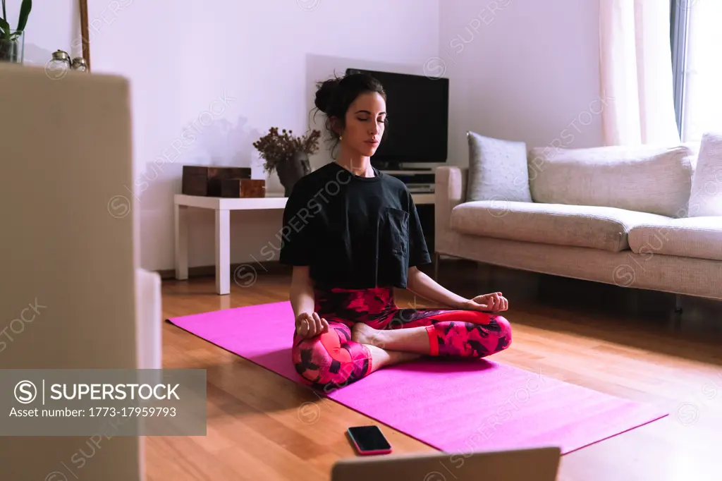 Young woman Property Released (PR)acticing yoga and meditation at home