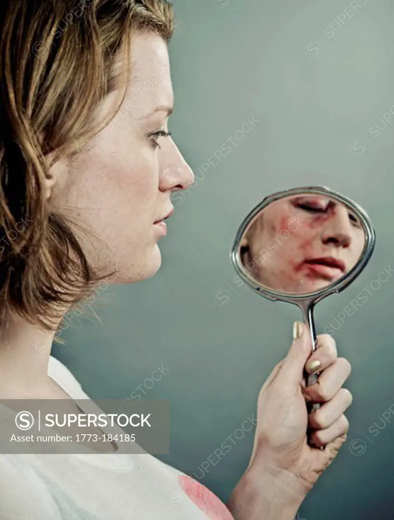 Woman examining her bruised face