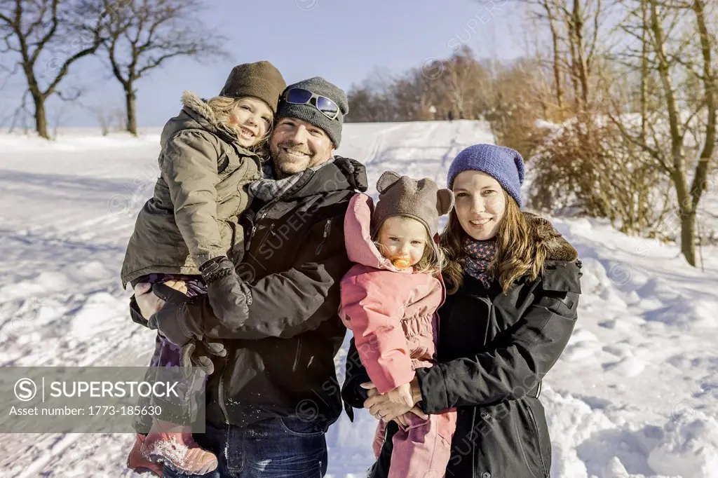 Family smiling together in snow