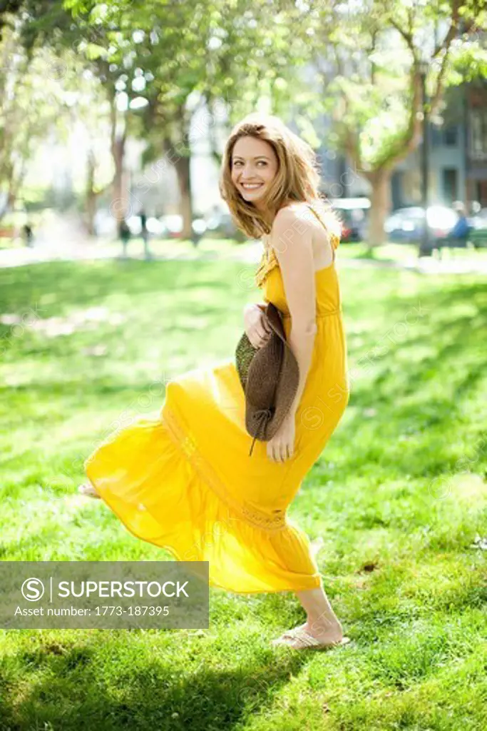 Woman carrying floppy hat in park