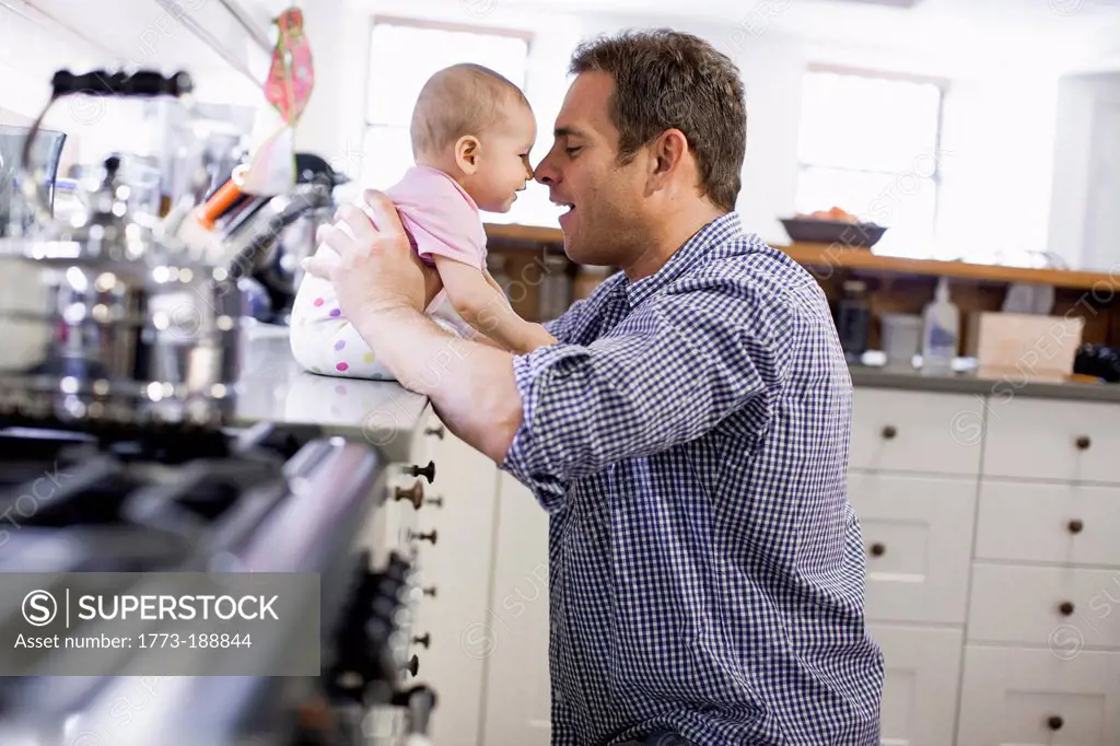 Father with baby daughter in kitchen