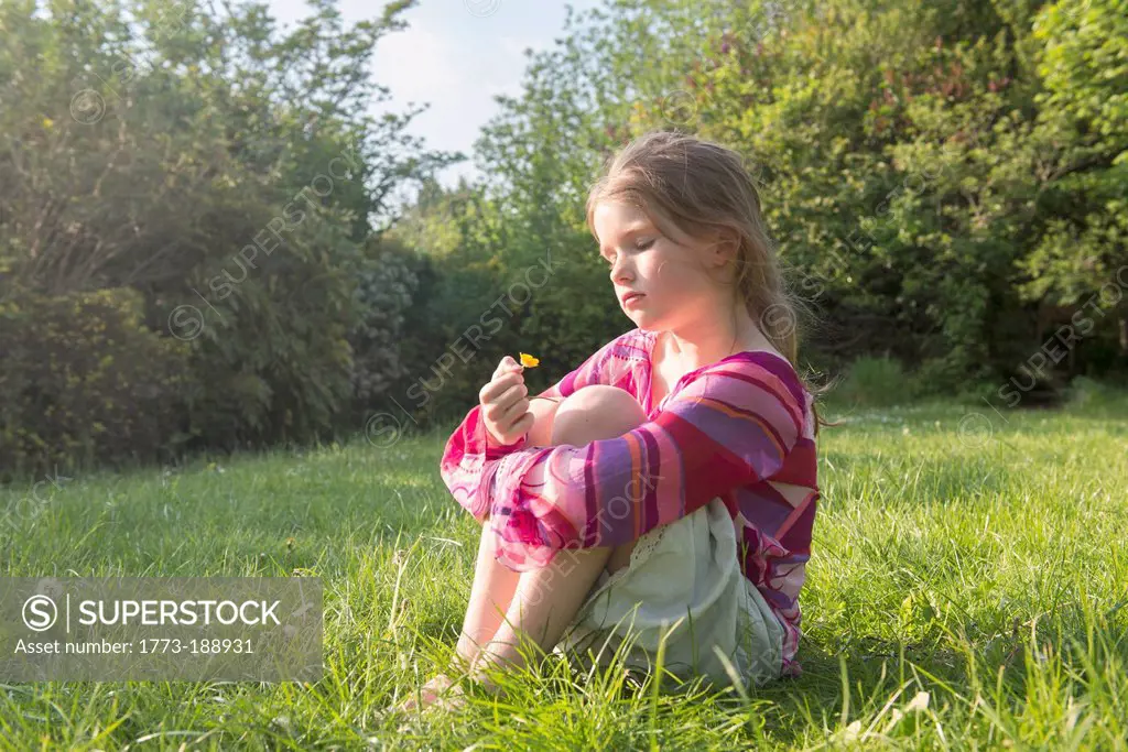 Girl sitting in grassy field