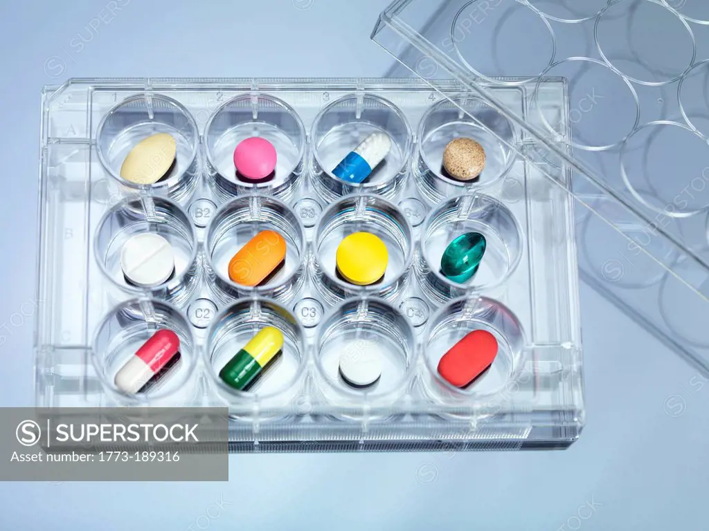 A variety of drugs sitting in a multi well sample tray Illustrating drug clinical trial