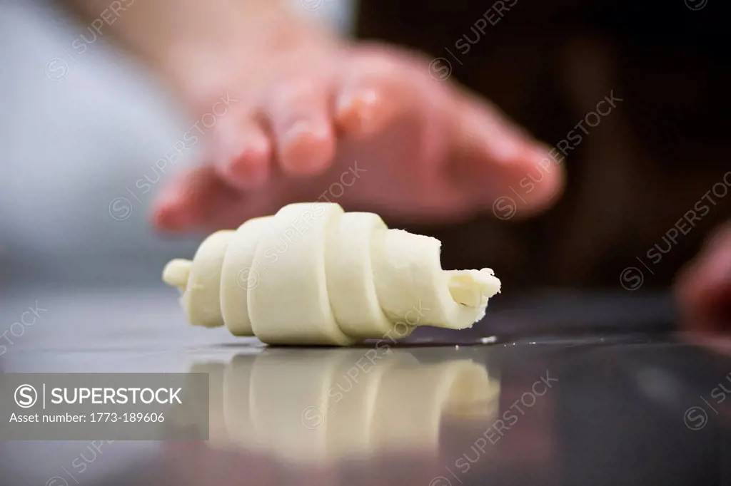 Close up of baker rolling dough