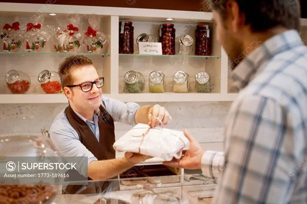 Cashier handing parcel to customer