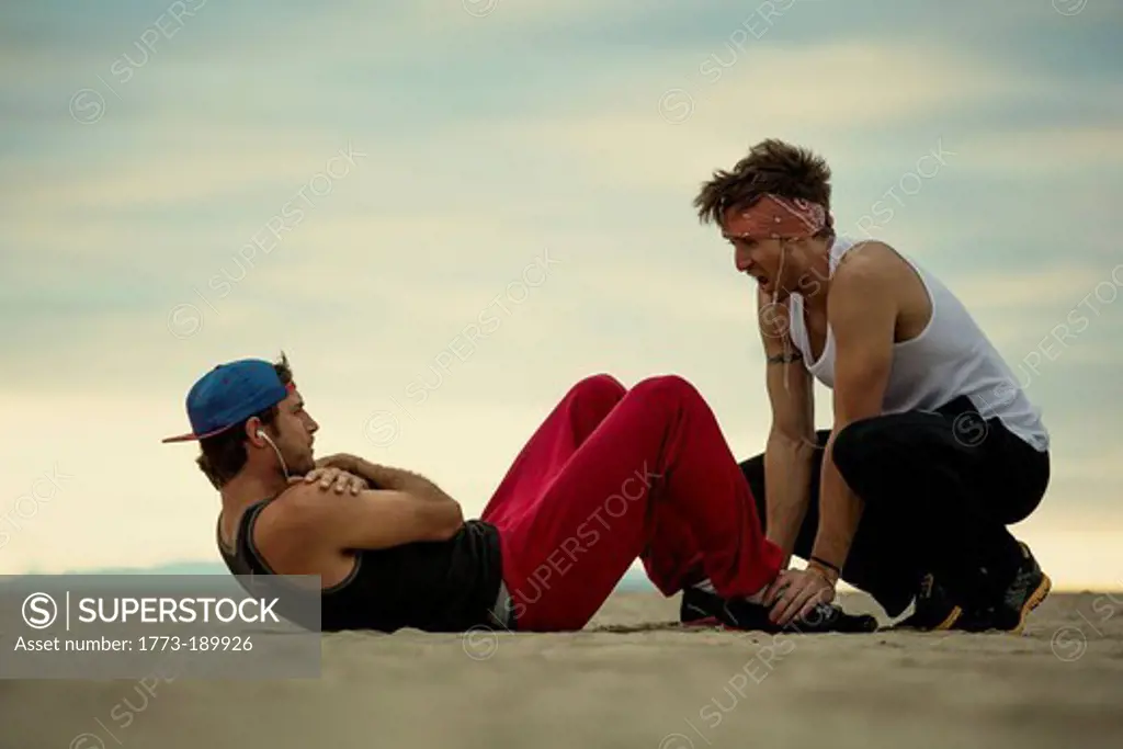 Men working out together on beach