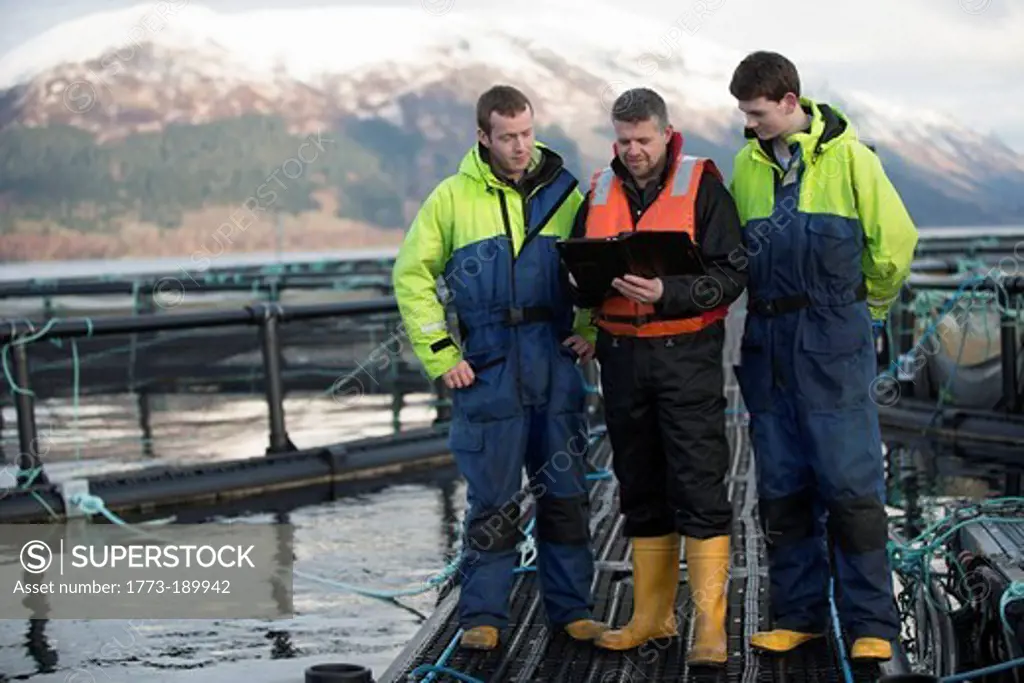 Workers on salmon farm in rural lake