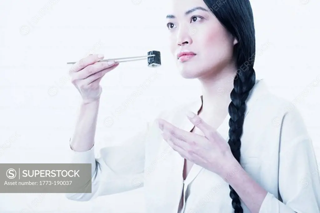 Woman smelling piece of sushi