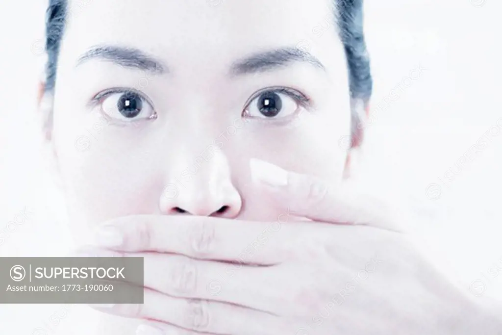 Close up of woman covering her mouth