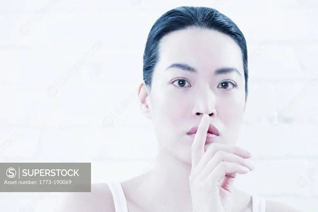 Woman covering lips with finger