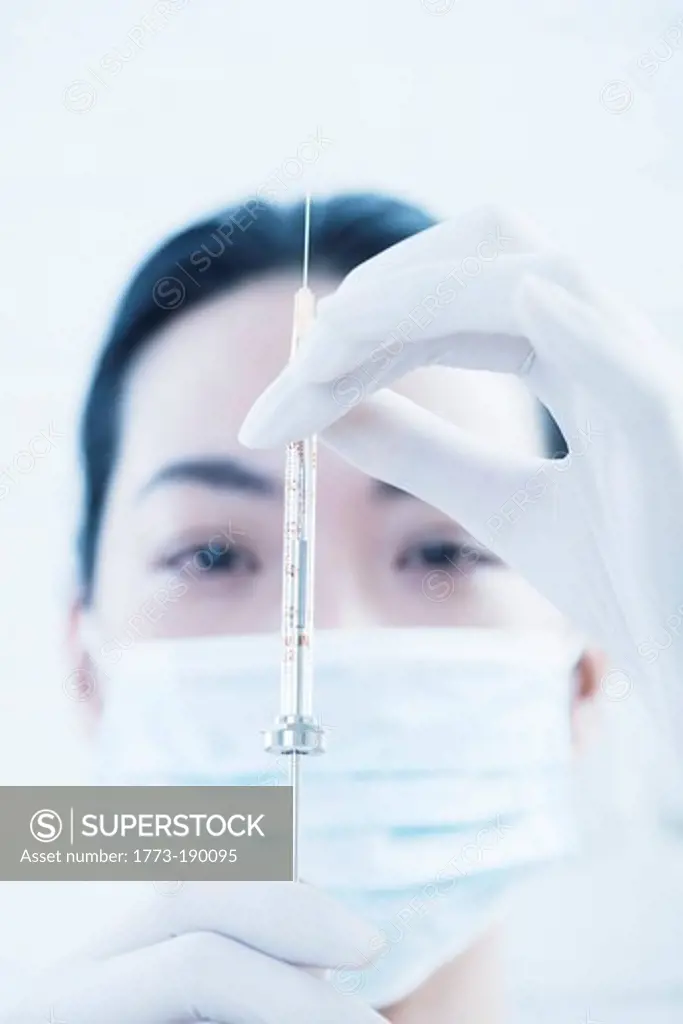 Doctor examining syringe