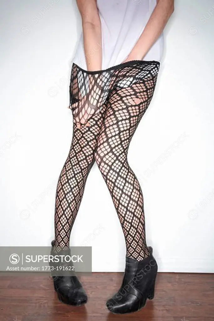 Woman in hands in fishnet tights
