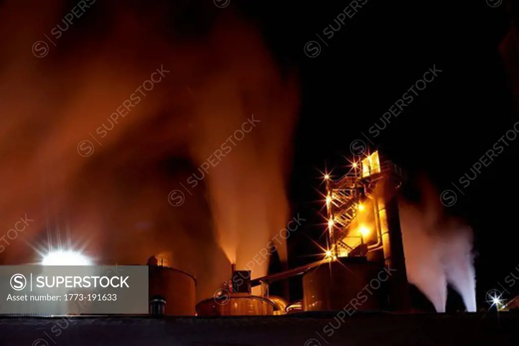 Smoke and lights at industrial plant at night