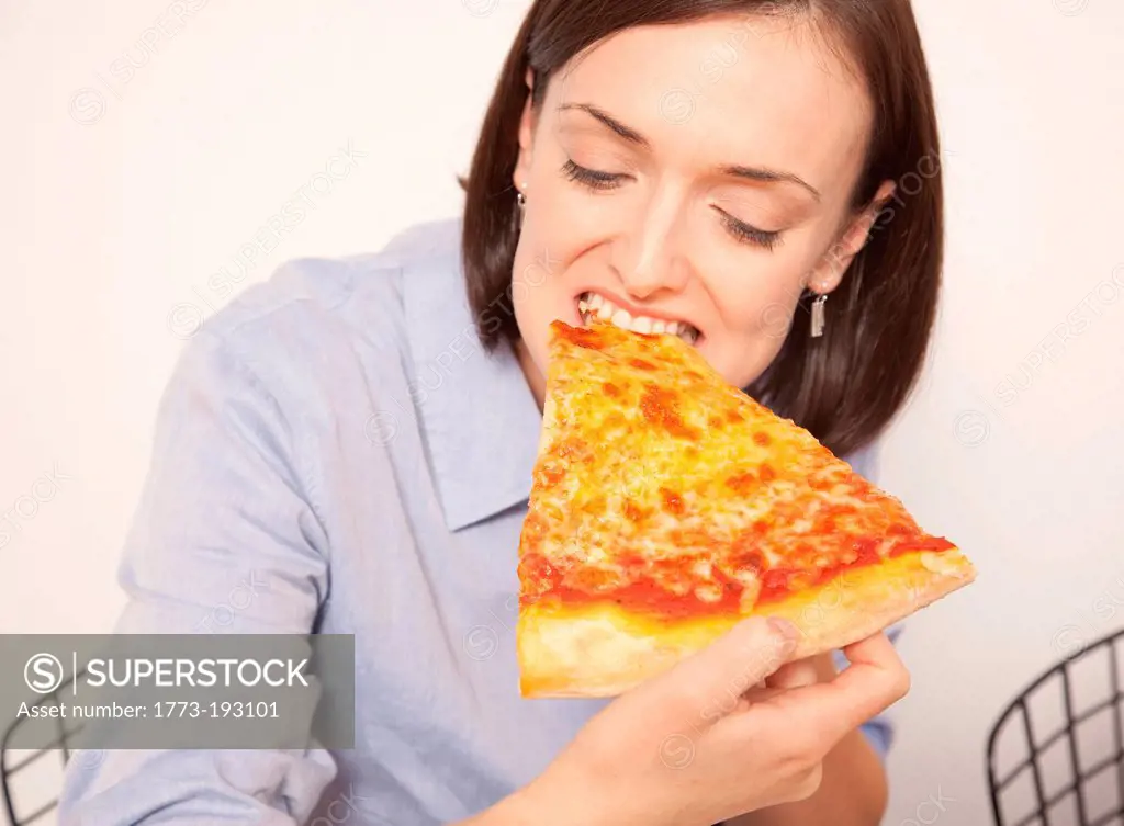Mid adult woman enjoying pizza slice