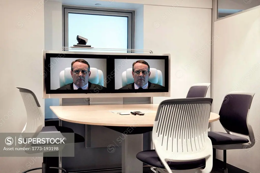 CEO on screens in empty video conference room