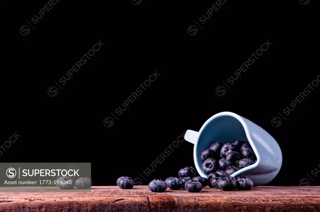 Blueberries spilling from jug
