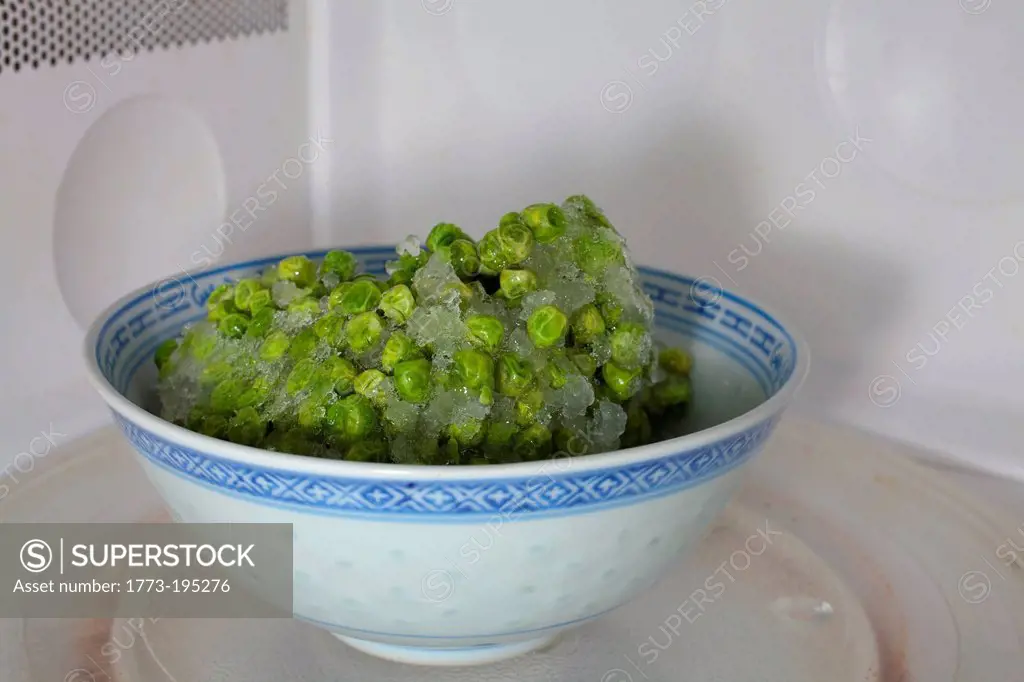 Frozen peas defrosting in microwave