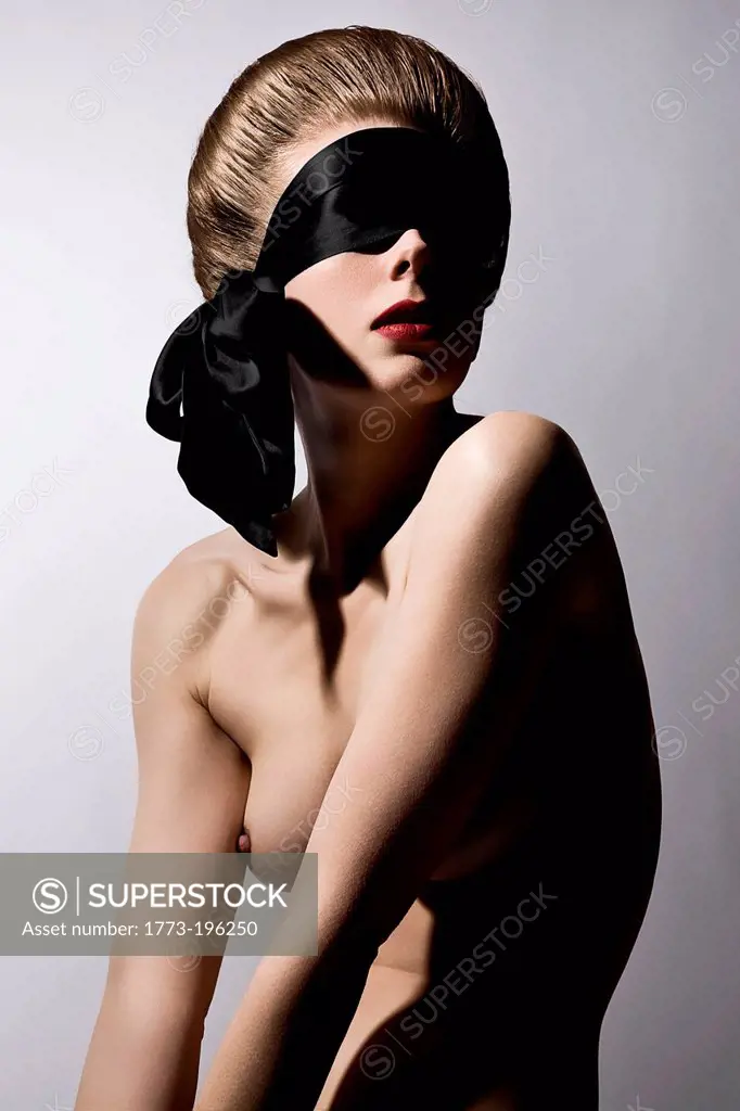 Portrait of naked young woman wearing blindfold