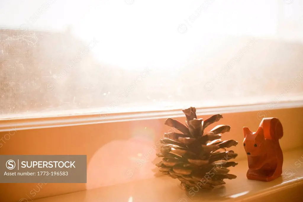 Pine cone and squirrel ornament on windowsill